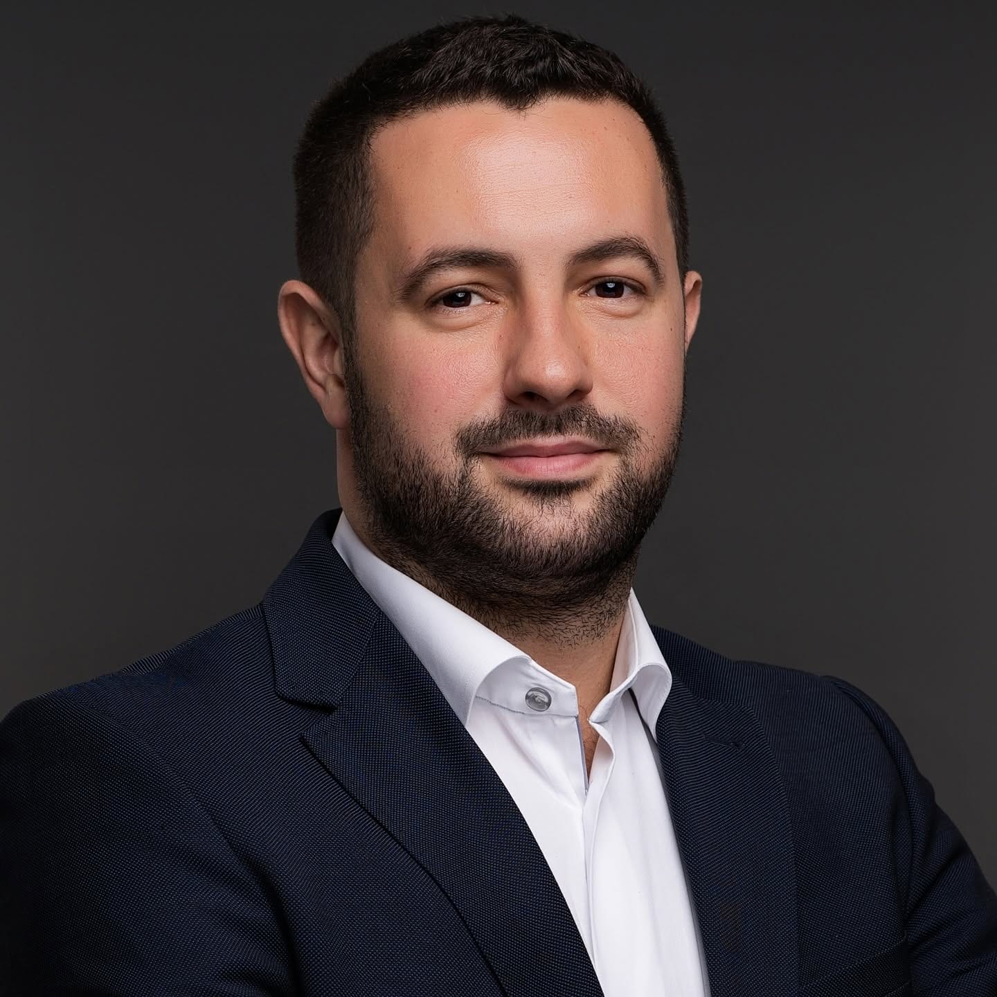 Studio headshot of a businessman in a dark suit